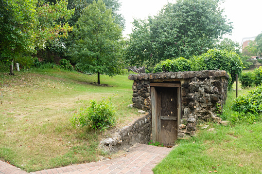 This is a photograph of a stone enclosure with a door in Washington Park in Macon, Georgia.