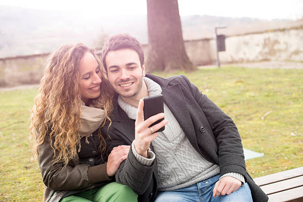 istock Young woman and man using a smart phone 166587028