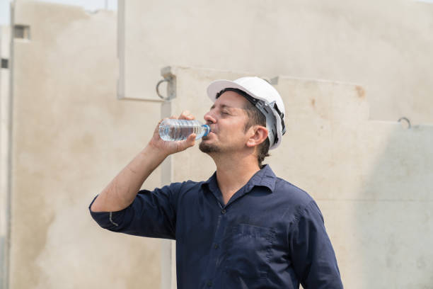 istock Male construction worker drinking water in break time at precast concrete wall construction site. Mature male worker working and wearing safety uniform, helmet in construction site 1665902744