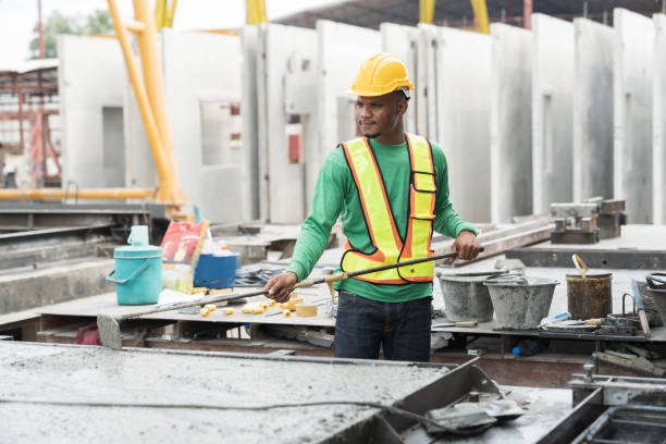 istock Asian male builder worker making levelling concrete floor to smooth at construction site. Construction worker uses long trowel spreading wet concrete pouring. Mason making smooth surface of concrete 1665905060