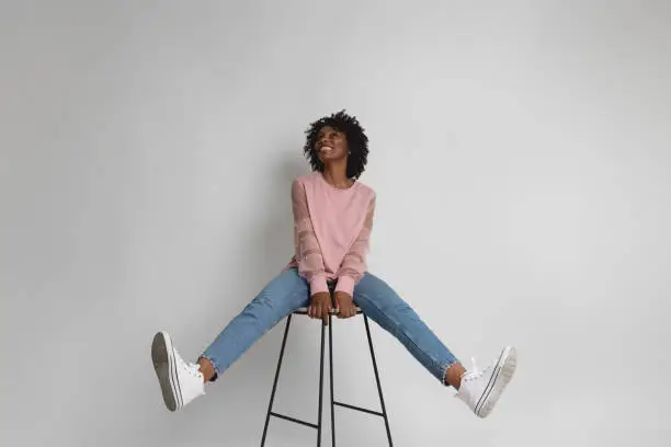 Black woman wearing a pink sweater laughing