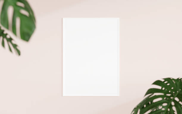 istock Clean and minimalist front view vertical white photo or poster frame mockup hanging on the wall with blurry plant. 3d rendering. 1665923270