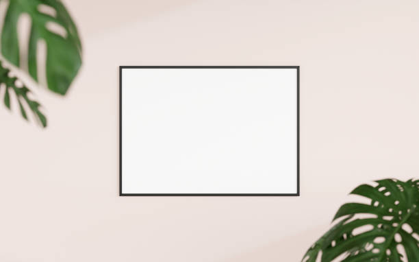 istock Clean and minimalist front view horizontal black photo or poster frame mockup hanging on the wall with blurry plant. 3d rendering. 1665923272