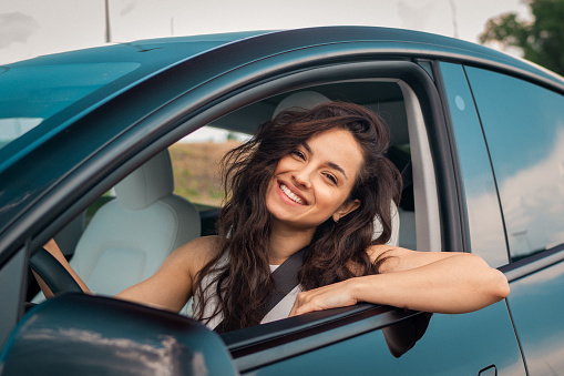 Smiling Caucasian lady on road, enjoying window view and traveling on holiday road trip. Travel, lifestyle, transport concept