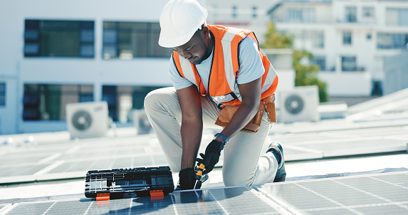 engineer man inspects construction of solar cell panel or photovoltaic cell by electronic device. Industrial Renewable energy of green power. factory worker working on tower roof.