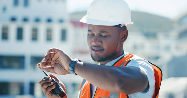 istock Construction, man and communication with walkie talkie for planning schedule, project management and check time on site. Reading, watch and person speaking with radio, tech or working on the clock 1665924935