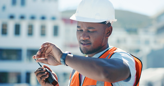 Construction, man and communication with walkie talkie for planning schedule, project management and check time on site. Reading, watch and person speaking with radio, tech or working on the clock