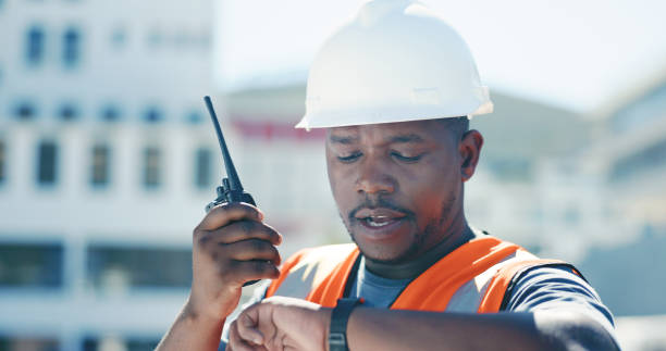 istock Construction, man and check time with communication on walkie talkie for planning schedule on site with project management. Reading, watch or person speaking with radio, tech and working on the clock 1665924942