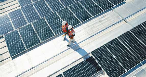 Energía renovable, paneles solares y equipo caminando en la planificación del techo para la inspección en negocios sostenibles. Ingeniería, sostenibilidad y energía fotovoltaica, hombres en el mantenimiento de electricidad desde arriba. photo