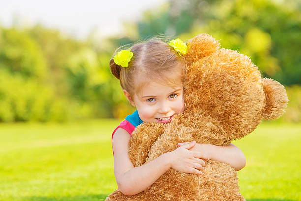 istock Young girl happily hugging a huge teddy bear 166594330
