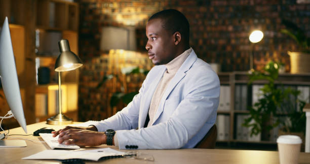 istock Black man, corporate and night, typing at computer with data analyst working overtime, productivity and marketing report. Keyboard, deadline and writing with research, admin and analysis in workplace 1665965418