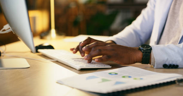 istock Hands, computer and a corporate person typing on a keyboard in a dark office at night for overtime work. Desktop, fingers and administration with a business employee working late in the evening 1665966224