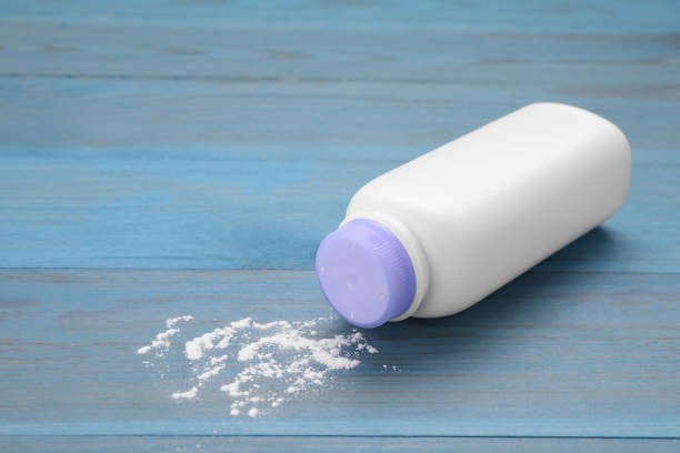 istock Bottle and scattered baby powder on light blue wooden table. Space for text 1665972170