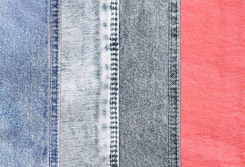 Horizontal or vertical background with denim patches of light grey, blue and coral colors cotton texture. Decorative striped backdrop with light blue, indigo, pink and gray color denim jeans fabric