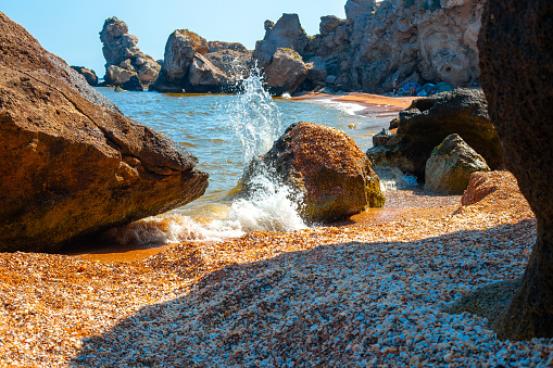 Sea bay with a rocky shore and a wave on a summer day. Travel and tourism.