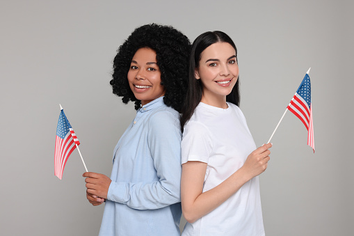 4th of July - Independence Day of USA. Happy women with American flags on grey background