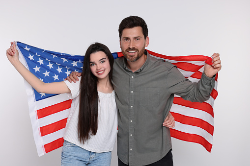 4th of July - Independence Day of USA. Happy father and his daughter with American flag on white background