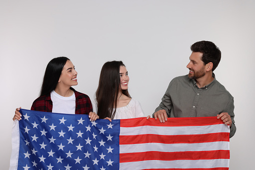 4th of July - Independence Day of USA. Happy family with American flag on white background