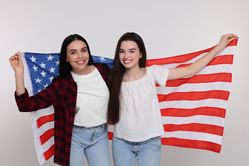 4th of July - Independence Day of USA. Happy woman and her daughter with American flag on white background
