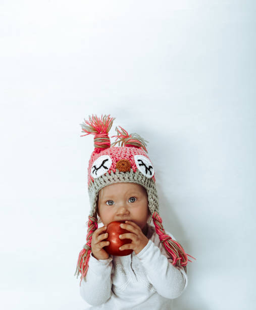 Little girl bites a red apple stock photo