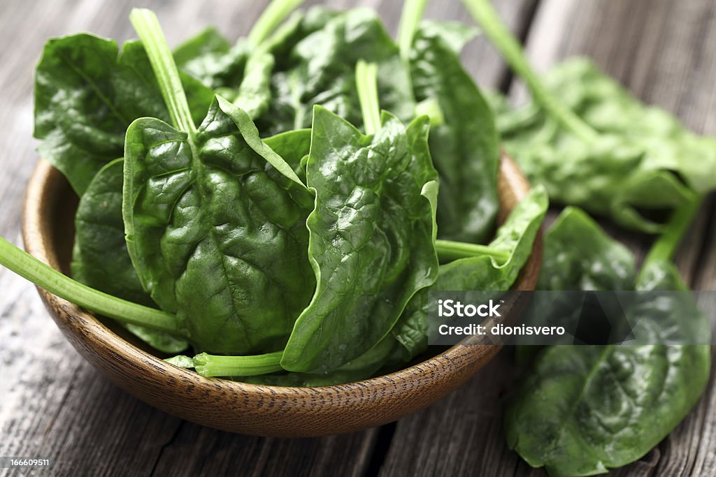 Spinach in a wooden plate Spinach leaves in a wooden plate Backgrounds Stock Photo
