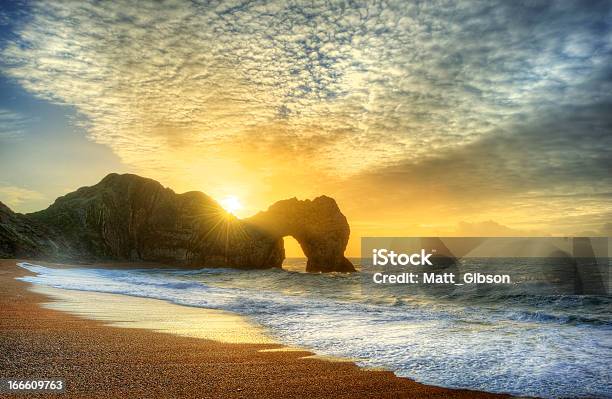 Vibrant Sunrise Over Ocean With Rock Stack In Foreground Stock Photo - Download Image Now