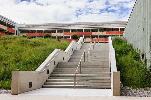 Large wide concrete staircase in a new residential area and a green flower bed