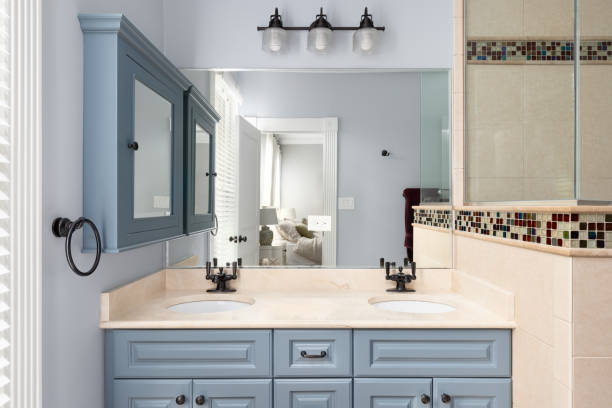 un baño con gabinetes azules, encimera de granito y ducha con azulejos. - medicine cabinet cabinet medicine bathroom fotografías e imágenes de stock