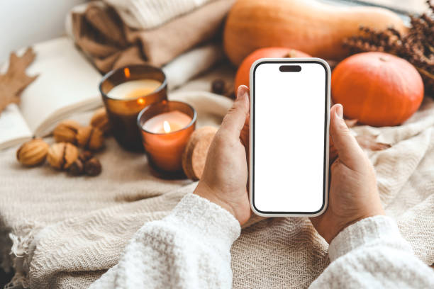 istock Phone with an isolated screen in hands, autumn mood 1666163590