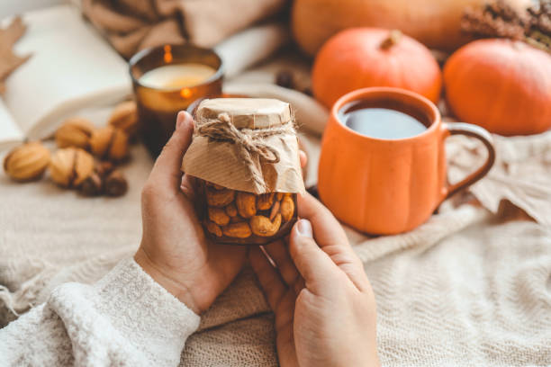 istock Jar of nuts with honey in hand 1666163608
