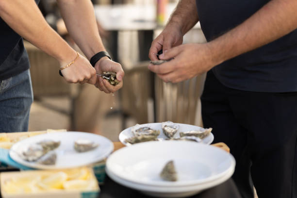 istock Two men open oysters with a knife 1666163698