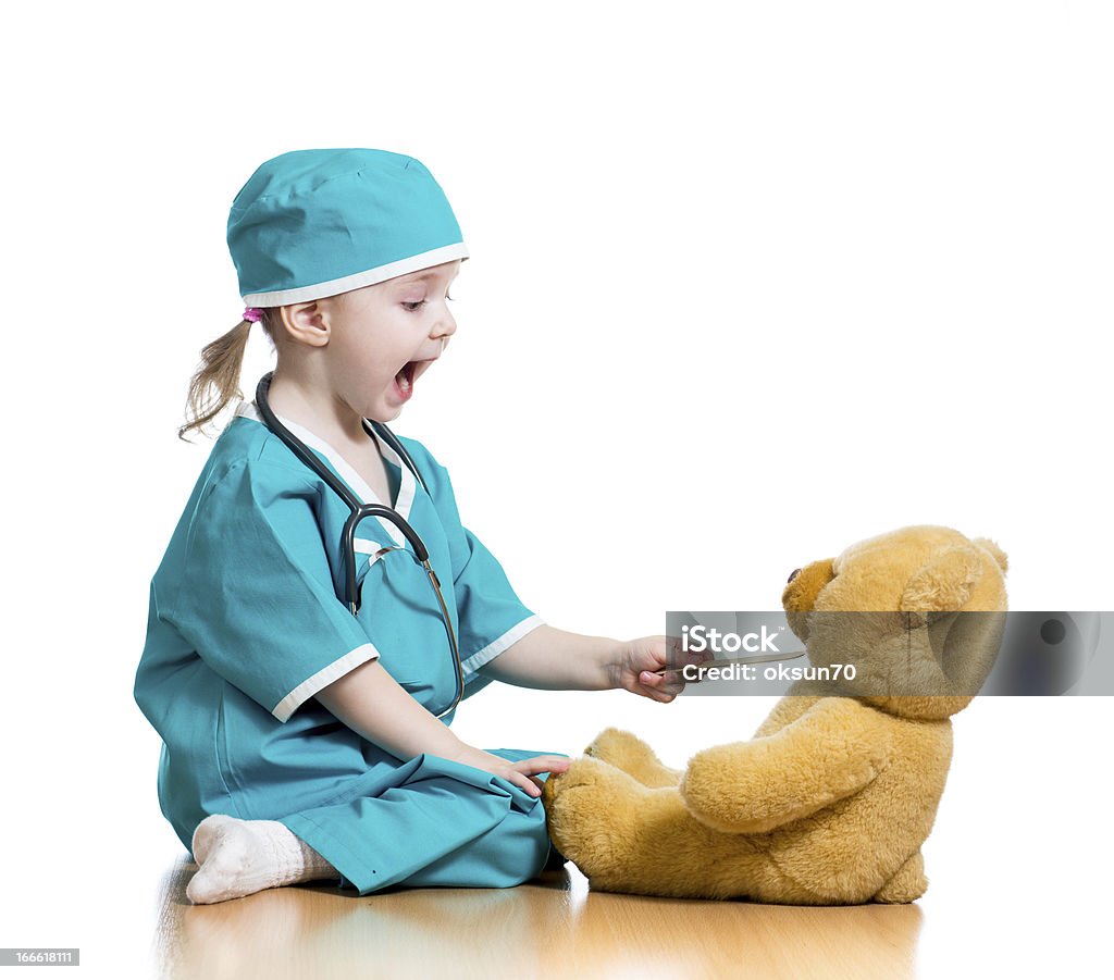 Adorable child dressed as doctor playing with toy Adorable child dressed as doctor playing with toy over white background Doctor Stock Photo