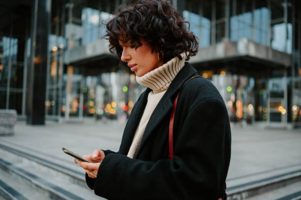 istock Pretty girl looking down to her smart phone while typing a text message on it. 1666188075
