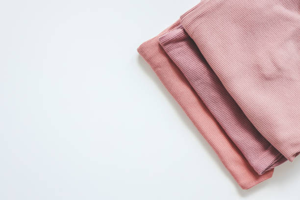 istock Stack of pink baby clothes on white background 1666190840
