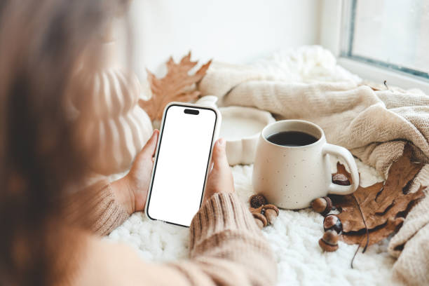 istock Phone with an isolated screen in hands, autumn mood 1666193077