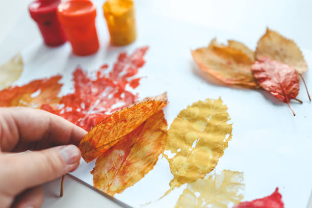 istock Children's autumn activity, leaf print on paper 1666194123