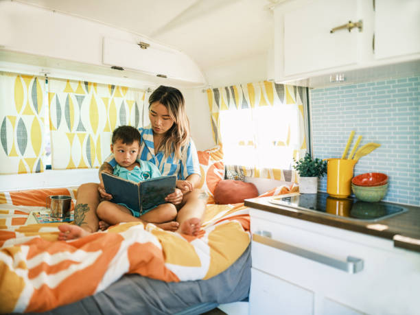 istock Asian mother and son reading book inside camping trailer 1666225935