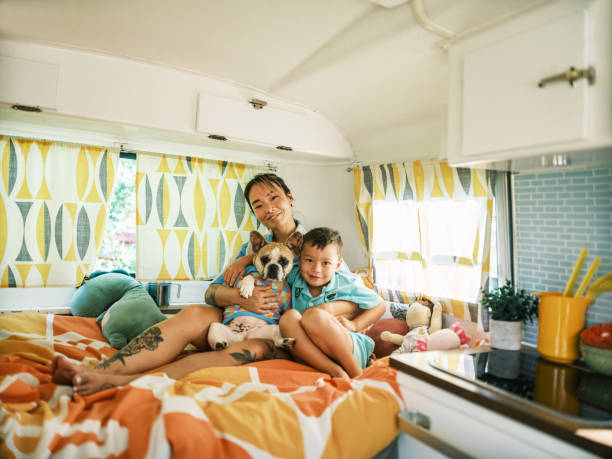 istock Asian mother, son and small dog playing on bed inside camping trailer 1666226481