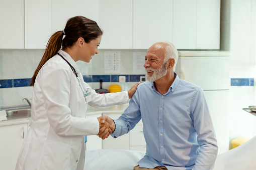 Shot of a Senior Patient Shaking Hands With Young Female Doctor at a Hospital