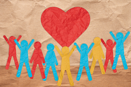 Paper colorful people and a red heart. The concept of love and kindness, donation