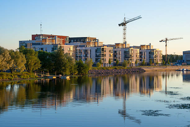 Modern apartment buildings on riverside in Pori Finland during sunset, more under construction