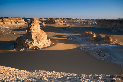 Wonderful white chalk rock formations in the White Desert view form above at sunset light - Egypt