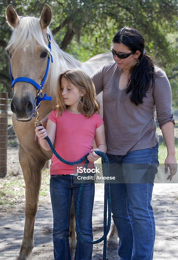 Instrutor de ensino de uma garotinha sobre o cavalo - Foto de stock de Colônia de Férias royalty-free