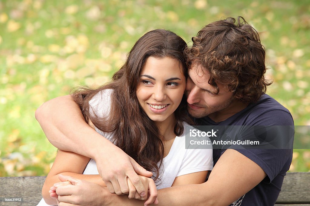 Couple hugging in a park Couple hugging in a park seated in a bench Adult Stock Photo