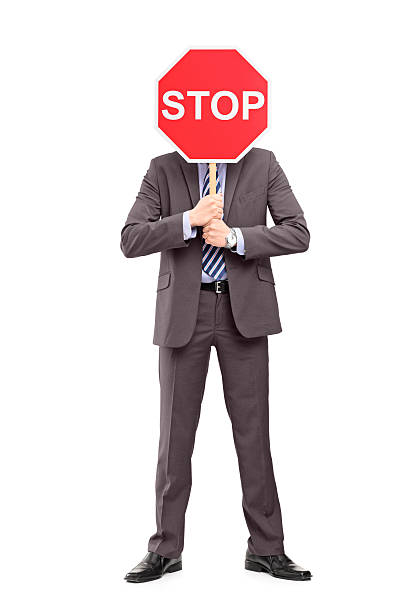 istock Man in suit covering his face with a stop sign 166632995