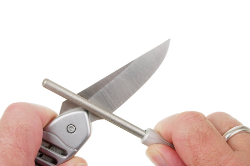 A lock knife being sharpened with a diamond hone.