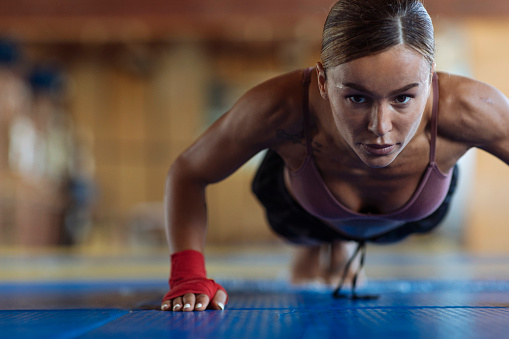 With dedication, a fit young woman engages in push-ups at the gym