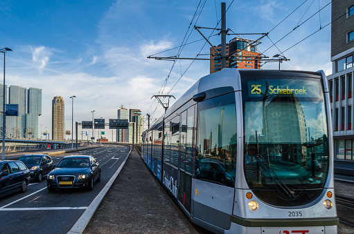 Rotterdam, the Netherlands - August 26, 2013: Urban scene, street with cars and a tram with skyscrapers in the background in Rotterdam, the Netherlands