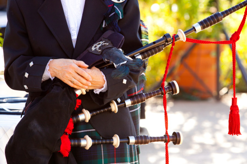 A woman holds her bagpipes at a traditional Scottish wedding.