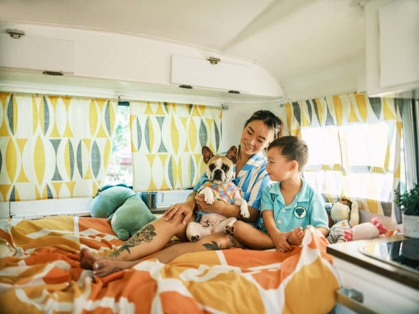 istock Asian mother, son and small dog playing on bed inside camping trailer 1666400598